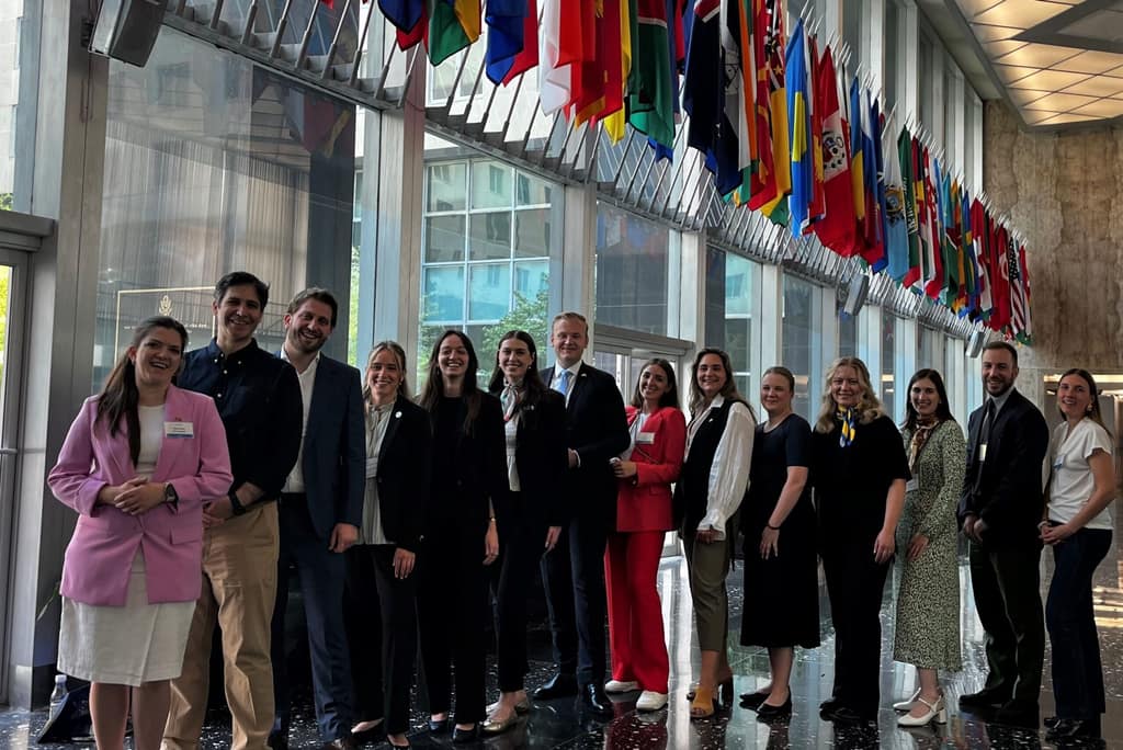 An international exchange delegation beneath the flags of visiting nations